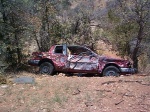 A car someone shot to hell neat Gunsight Pass.