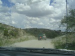 A very slow rancher type person carting a dumpster.