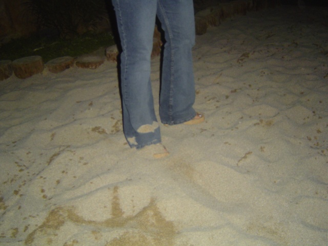 Nicole's feet, covered in sand.